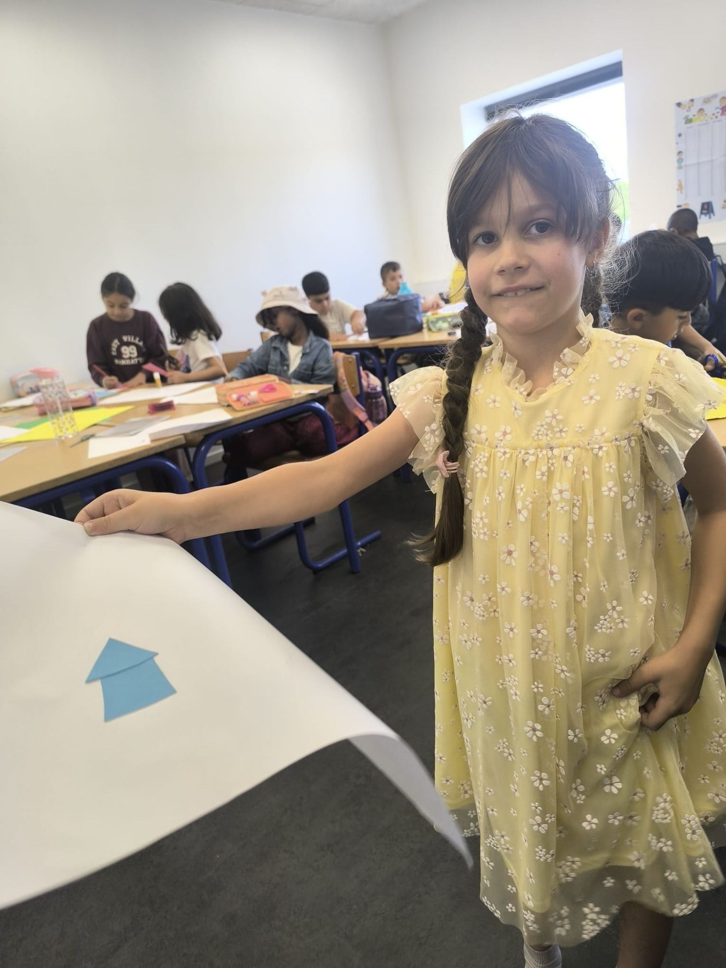 Elev viser stolt sit papirprojekt frem i klassen