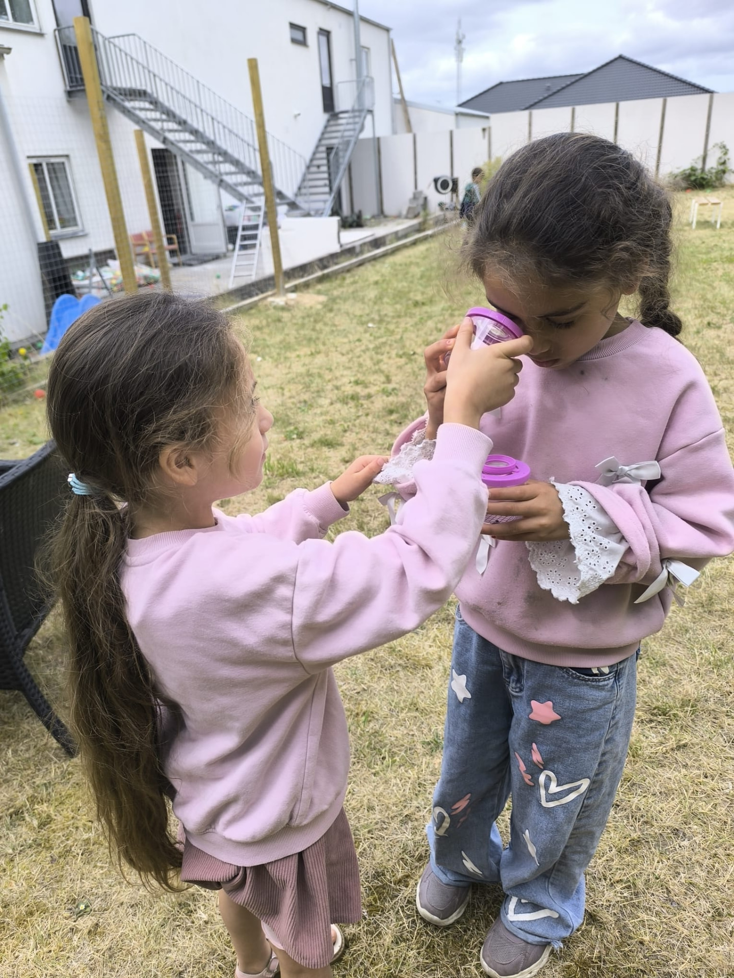 Elever kigger på naturfund gennem lup udenfor